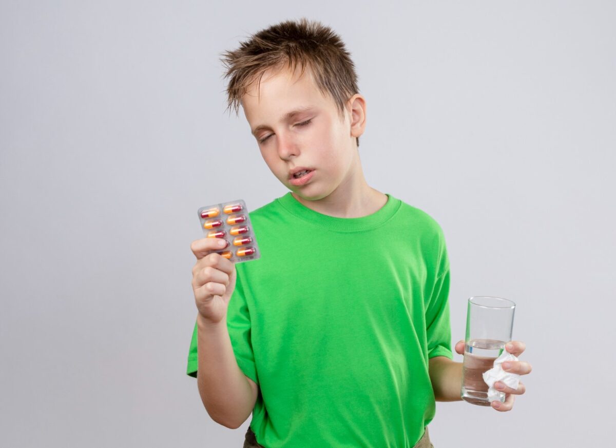 Boy Feeling Unwell Holding Glass Water Pills The Addictive Power: Is Adderall Addictive?